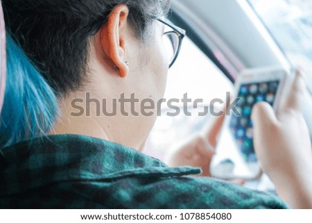 Asian woman play mobile phone while travel in car. Technology cell phone isolation. Internet and social media