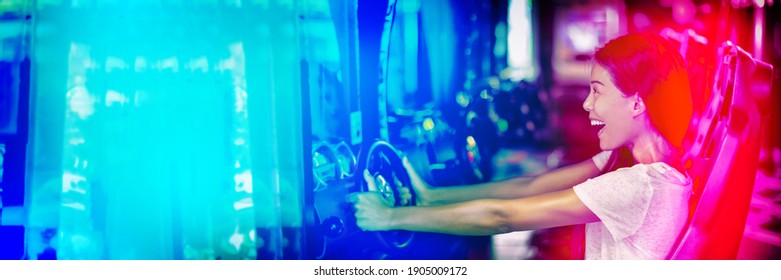 Asian Woman Playing Car Racing Game At Japanese Gaming Cyber Arcade Cafe. Driving Game Machine Girl Having Fun Playing Racing Car Videogame Driving Virtual Sports Cars Simulator Banner.