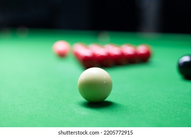 An Asian woman playing snooker.