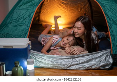 Asian woman playing and staying in tent with her daughter and having fun with camping tent in their bedroom a staycation lifestyle a new normal for social distancing in coronavirus outbreak situation - Powered by Shutterstock