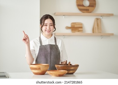 Asian Woman Pointing In The Kitchen