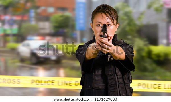 Asian Woman Police Officer at Crime scene\
Pointing firearm