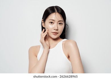 Asian woman posing with one hand close to her face