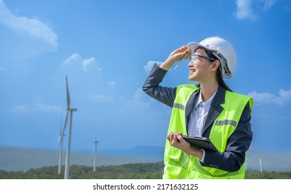 Asian Woman Power Engineer Are Working With Wind Turbines.Electrical Engineer Female Renewable Energy Power Plant Sustainability Concept.Professional Expert Wind Power Clean Energy Farm.