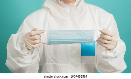 Asian woman in PPE suit ,medical gloves and hloding face mask  or medical mask on green, Tiffany Blue background.