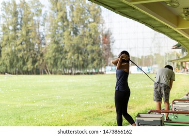 Asian Woman Practicing His Golf Swing At The Golf Driving Range.