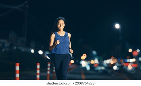 Asian woman practicing running at night - Powered by Shutterstock