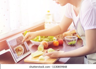 Asian Woman Prepare Ingredients For Cooking Follow Cooking Class Online Course On Website Via Tablet. Cooking Content On Internet Technology For Modern Lifestyle Concept