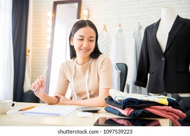 Asian Woman Professional Fashion Designer Working In Modern Office