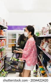 Asian Woman With Protective Face Mask With Shopping Basket In Department Store