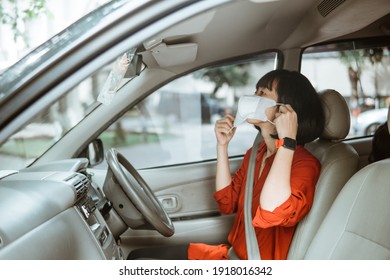 asian Woman in protective mask driving a car on road. Safe traveling.