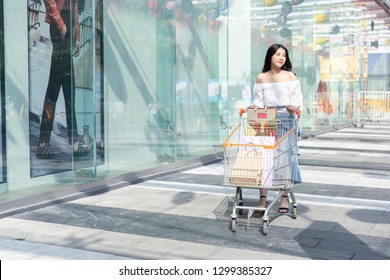 
Asian Woman Pushing Car Shopping