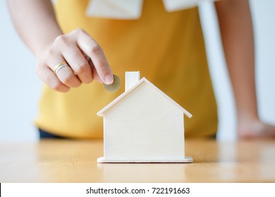 Asian Woman Putting Money Coin In To House Piggy Bank Metaphor Saving Money Financial For Buy The Home Shallow Depth Of Field Select Focus On House