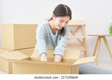 Asian Woman Putting Things In The Cardboard Box