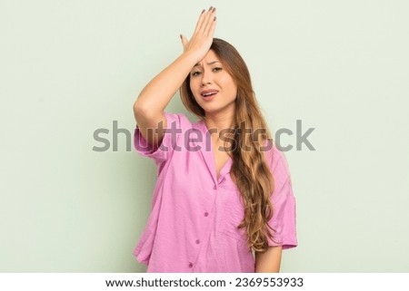 asian woman raising palm to forehead thinking oops, after making a stupid mistake or remembering, feeling dumb