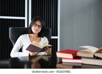 Asian woman reading a book in the library.