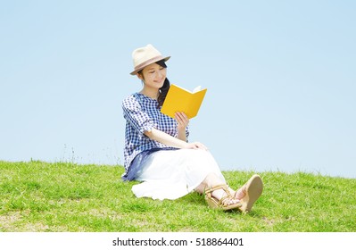 Asian Woman Reading The Book In The Park