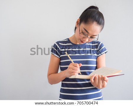 Asian woman reading book and thinking for ideas.