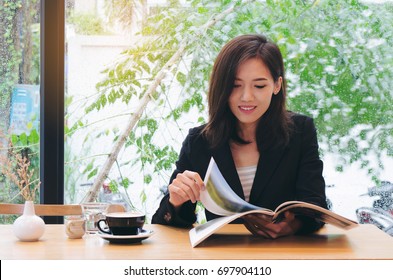 Asian Woman Reading Magazine In Coffee Shop.business Concept.