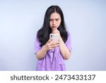 Asian woman reading news in mobile app and wondering fake news.