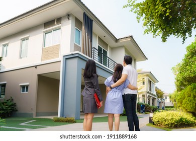 Asian Woman Real Estate Broker Agent Showing A House Detail In Her File To The Young Asian Couple Lover Looking And Interest To Buy It. Buying A New House.
