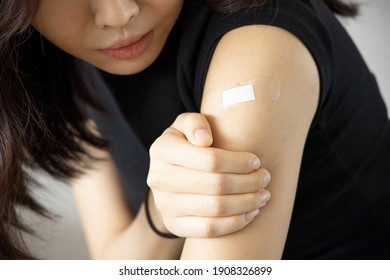 Asian woman receiving getting vaccinated immunity with bandage on her upper arm, concept of innoculation, vaccination, side effects of vaccine