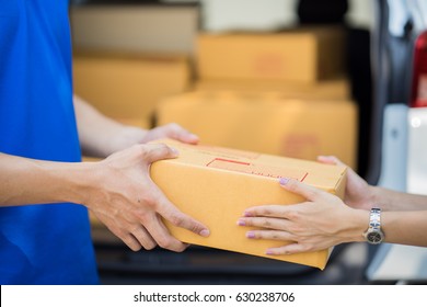 Asian Woman Receiving A Package At Home From A Delivery Guy