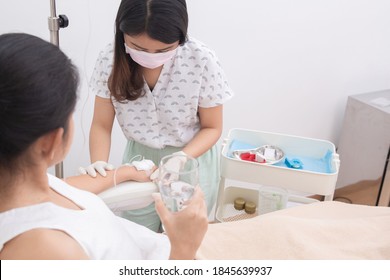Asian woman receiving vitamin IV infusion or chemotherapy drip in hospital or beauty salon. Healthcare and medicine concept