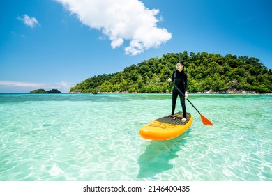 Asian woman relax on the beach with SUP BOARD at lipe island in summer season, Thailand