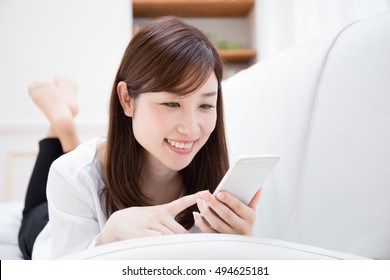 Asian Woman Relaxing In The Room.