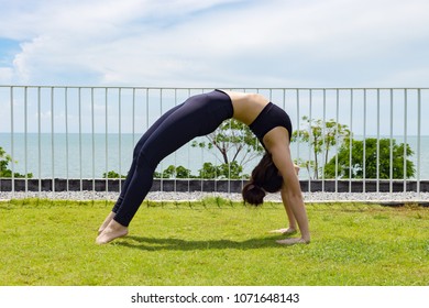 Asian woman relaxing in yoga bridge Pose stretching exercises muscle for warm up on the beach in with seaside,Feeling so comfortable and relax in holiday - Powered by Shutterstock