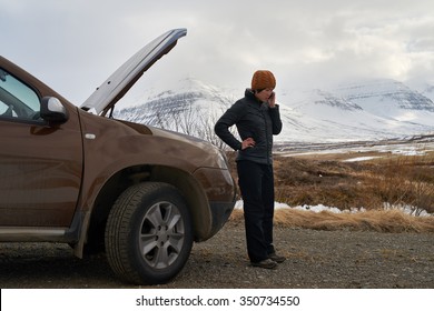 Asian Woman With Rental Car Breakdown Engine Trouble With Hood Up, Calling With Mobile Phone For Help, Stranded In Winter