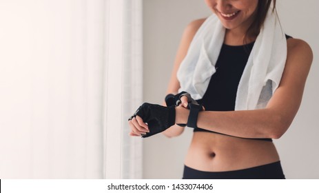 Asian Woman Resting And Using Smart Watch After Play Yoga And Exercise At Home Background With Copy Space.Concept Of Sport Technology To Checking Health Data.