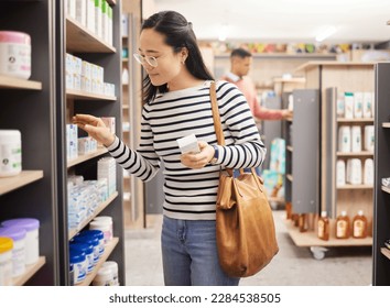 Asian woman, retail shopping and shelf in store for products, grocery stock and choice of brands. Female shopper, customer and supermarket aisle for groceries, sales decision and consumer buying - Powered by Shutterstock