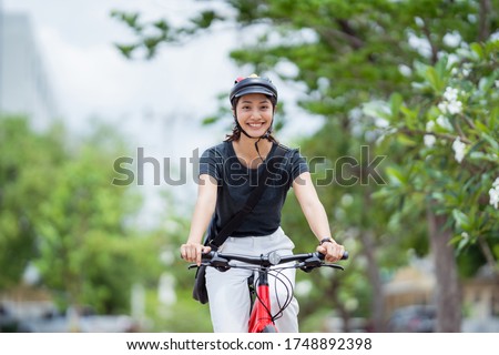 Asian woman ride bikes to work she is happy and safe.