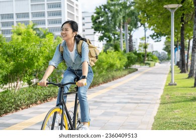 Asian woman riding a bicycle in the park. - Powered by Shutterstock