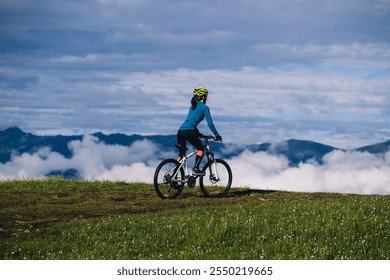 Asian woman riding mountain bike on beautiful mountain top - Powered by Shutterstock