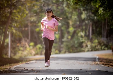 Asian Woman Runner Running In The Morning Tropical Forest Trail. Concept Nature And Sport Lifestyle.