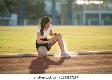 Asian woman runners knee and calf injuries due to practice She uses spay to reduce injuries. - Powered by Shutterstock