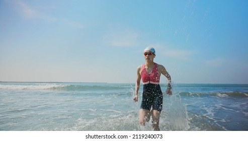 Asian Woman Is Running In Water Training For Triathlon At Beach