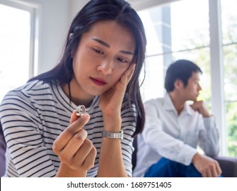 Asian woman sat with the wedding ring, thinking seriously sad and sad after arguing with her husband. The problems of lovers must separate. Family issues, divorce, washing, causing loss