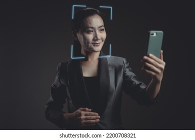 Asian Woman Scans Face By Smart Phone Using Facial Recognition System. Isolated On Background.