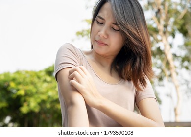 Asian woman scratching her arm; concept of dry skin, allergic skin inflammation, body care, fungus infection, eczema, dermatitis, rash, mosquito or insect bite