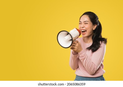 Asian Woman Screaming While Holding Megaphone With Two Hands Making Announcement