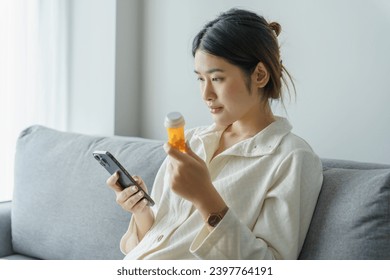 Asian woman Search for information on Internet in smartphone with holding bottled drug. girl reading information online on mobile phone medicine healthcare product concept. - Powered by Shutterstock