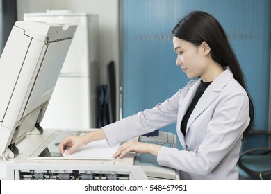 Asian Woman Secretary Using Copy Machine In The Office