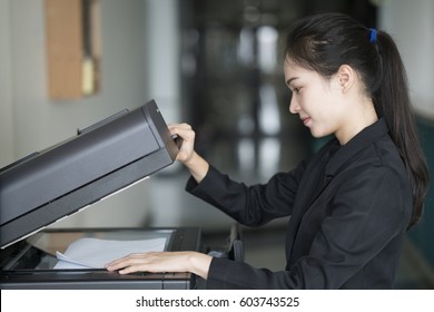 Asian Woman Secretary Using Copy Machine In The Office