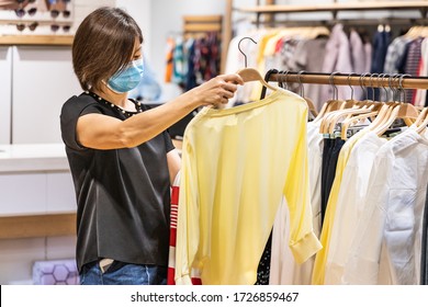 Asian Woman Shopping Apparels In Clothing Boutique With Protective Face Mask As New Normal Requirement In Malaysia