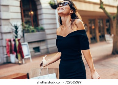 Asian Woman With Shopping Bags Enjoying On City Street. Female Walking Outdoors With Shopping Bags And Smiling.