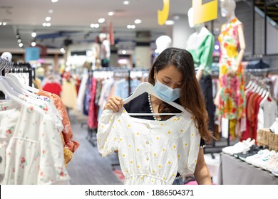 Asian Woman Shopping In Clothing Store With Face Mask,New Normal Shopping Concept